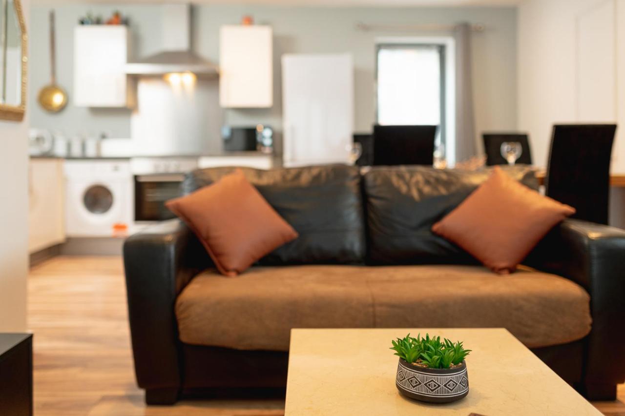 a living room with a brown couch and a table at Sidemersey Livings Liverpool Corporate & Relocation Apartment in Liverpool